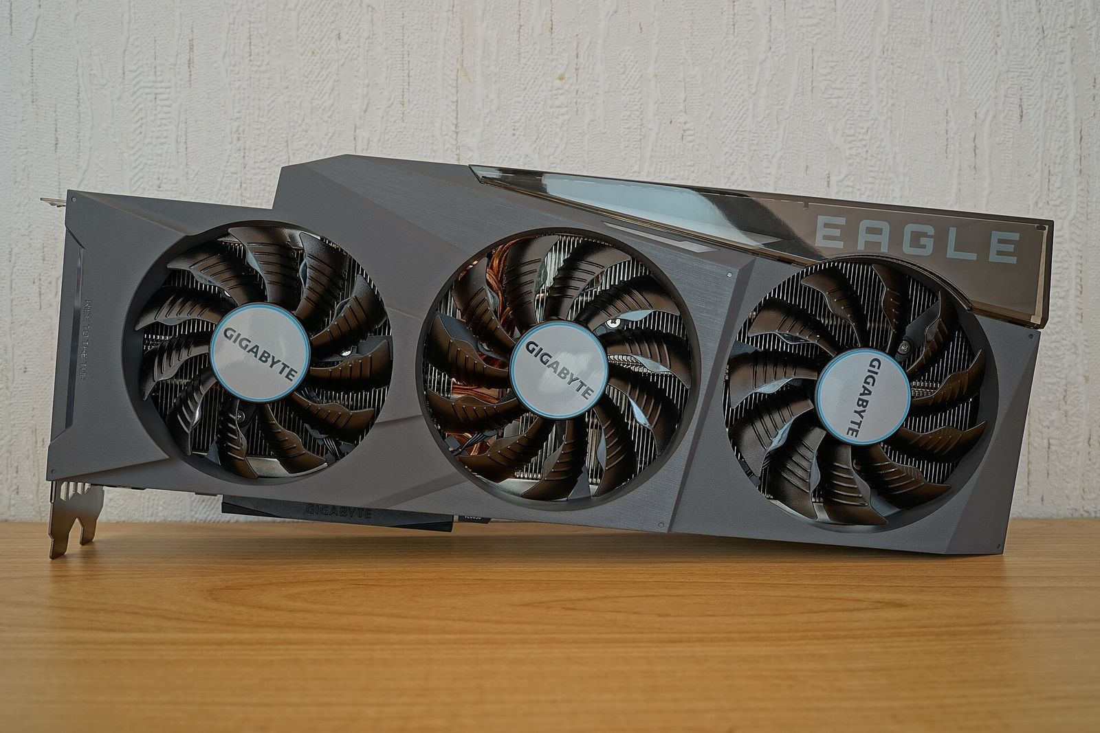 A Gigabyte GeForce RTX 3090 graphics card on a wooden desk